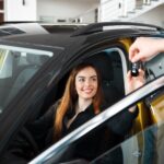 Car dealership seller gives client a car key